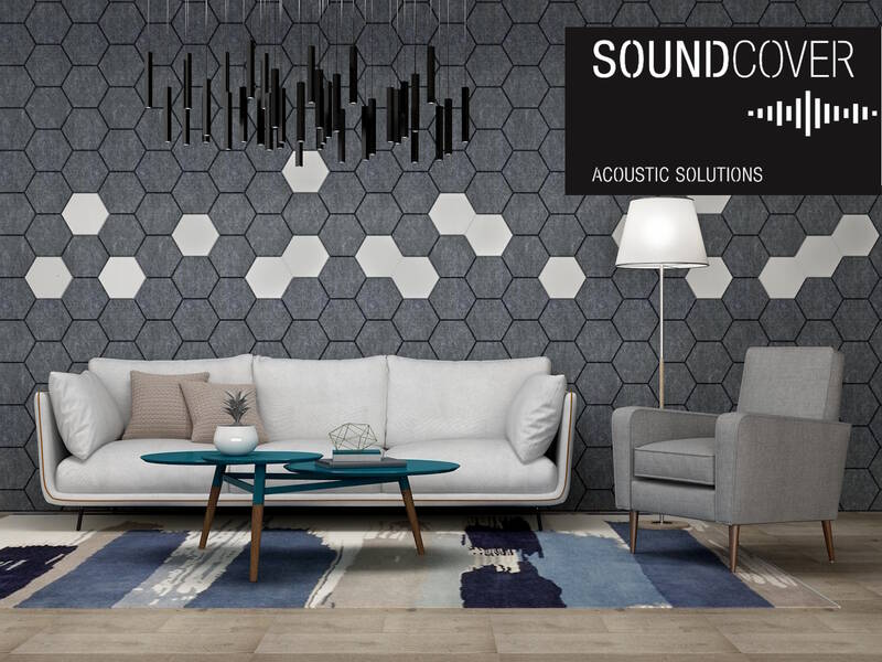 Modernes Wohnzimmer mit weißem Sofa, grauem Sessel, blau-grauem Teppich und sechseckiger Wandverkleidung aus Akustikplatten. SoundCover Acoustic Solutions Logo oben rechts
