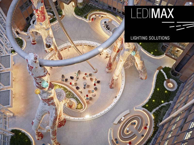 Vogelperspektive auf einen modernen Innenhof mit organisch geformten Sitzbereichen und beleuchteten Skulpturen, LEDIMAX Lighting Solutions Logo oben rechts